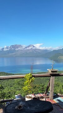 Vertical shot of active Mount Lewotobi twin volcano in East Flores Indonesia seen from a wooden terrace balcony