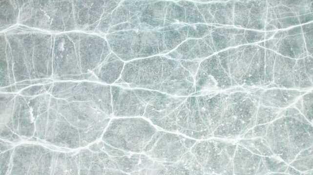 Drone view of half frozen lake with ice on water, close up view of blue ice crack and bubbles in earl spring day, top view ice floating on lake, 4k real time footage travel concept.