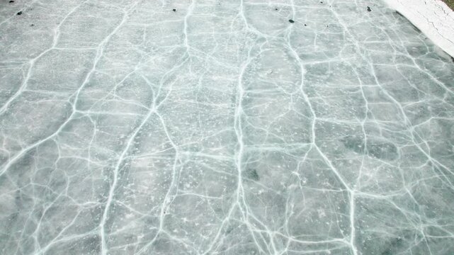 Drone view of half frozen lake with ice on water, close up view of blue ice crack and bubbles in earl spring day, top view ice floating on lake, 4k real time footage travel concept.