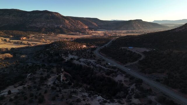 Aerial View of Road Traffic Under Hills of Ute Mountain Near Cortez Colorado USA on Golden Hour Sunlight