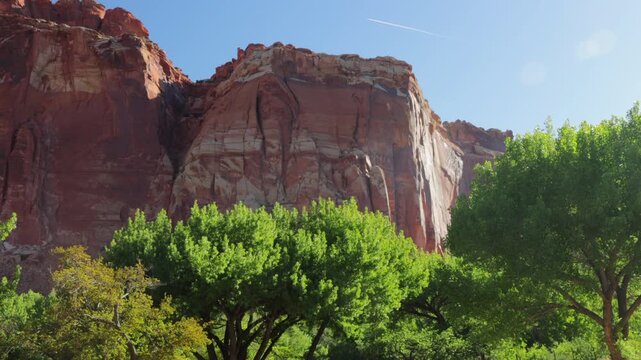 An airplane contrail, or condensation trail, passes over the historic Fruita district in Capitol Reef NP - Part 2 of 2