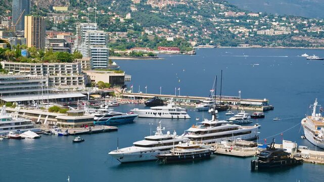Aerial view of luxury mega yachts docked in Port Hercules harbor Monaco during sunny day.