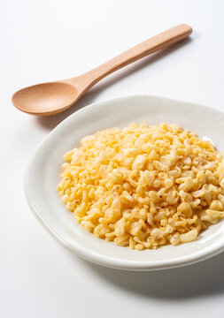 Tenkasu served on a plate placed on a white background.