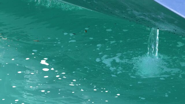 Bilge Pump Discharging Water from Yacht Hull into Turquoise Sea