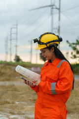 Obraz premium Technicians are using surveying equipment to inspect the integrity of the road construction at the wind turbine farm. 