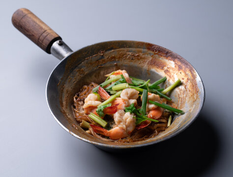 Baked prawns with glass noodles and herbs in traditional pot