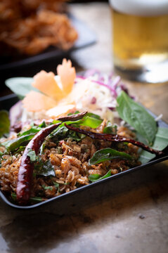 Stir fried crispy small shrimps with herbs on grey background.