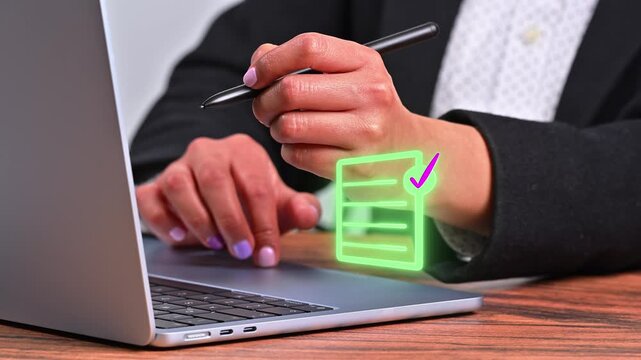 Conceptual image showing a professional's hands using a stylus on a laptop to check a bright green box