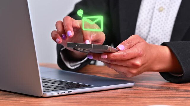 Digital communication concept. Female hands holding a mobile device with a holographic email notification icon