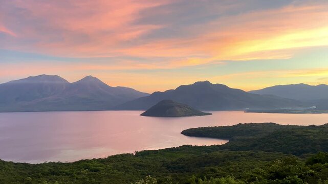 Beautiful tropical bay and mountain landscape during purple and pink twilight golden hour