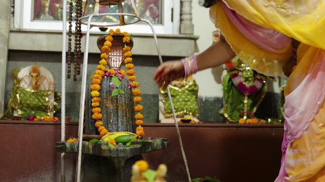 indian devotee worshipping sacred shivling with fruits offerings