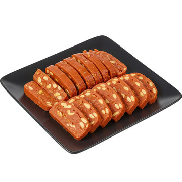 Sliced torrone candy with almonds arranged on a black plate isolated on white background