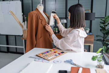 Asian woman designer selecting fabric samples while creating fashion collection in creative studio © Charlie's