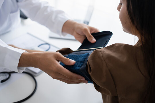 Doctor checking  patient arterial blood pressure. Health care measuring blood pressure of patient