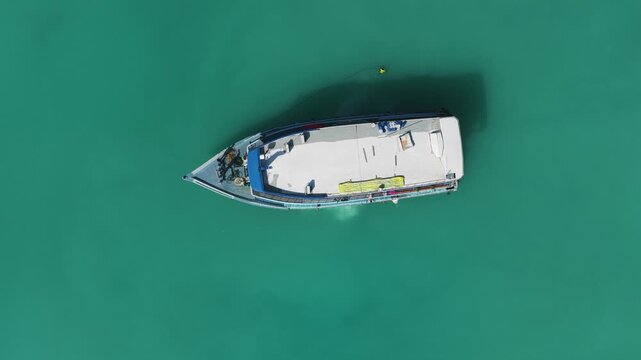 Aerial view of a traditional dhoni boat floating on the calm turquoise sea Kudahuvadhoo, Dhaalu Atoll, Maldives.