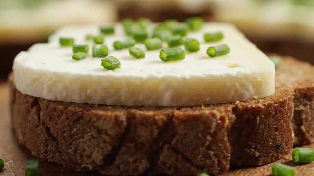 Close-up of a rustic appetizer featuring fresh soft cheese, like ricotta or farmer's cheese, garnished with dill on a slice of dark rye bread