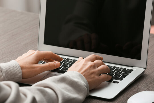 Young female programmer working with laptop in office, closeup