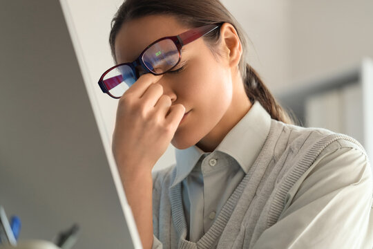 Tired female trader in eyeglasses at office, closeup