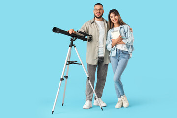 Obraz premium Young couple with telescope on blue background