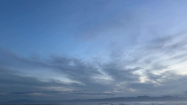 伊豆半島の山並みと薄雲が流れる夕暮れの海岸