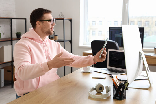 Portrait confused of male programmer working with tablet computer in office