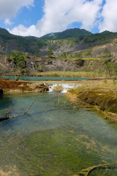 Lake and flowing water stream inside Panguna mine pit in Autonomous Region of Bougainville, Papua New Guinea