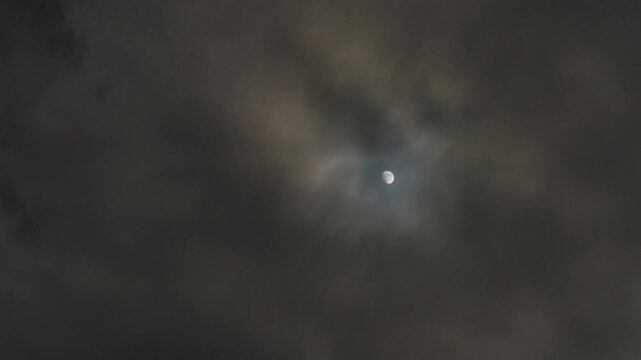 Full Moon Shining Through Clouds in Dark Night Sky