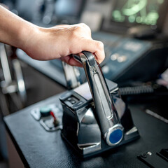 Captain hand holding throttle control or engine control lever on boat dashboard with GPS navigation and marine radar in wheelhouse or ship bridge. Speed adjustment instrument for seafaring technology © zephyr_p