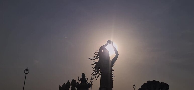 Silhouette of Giant Multi Armed Mythological Statue Against Bright Sun at Ujjain Corridor