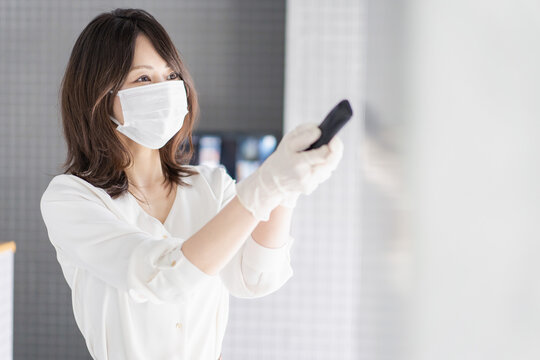 感染拡大防止のためにお客様の体温を計測するスタッフ