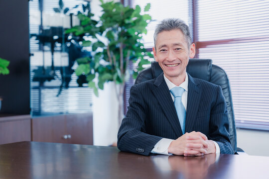 笑顔で椅子に座る経営者の男性