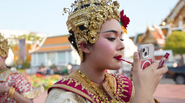 Thai Traditional Dancer Applying Red Lipstick Before Performance at Wat Suthat