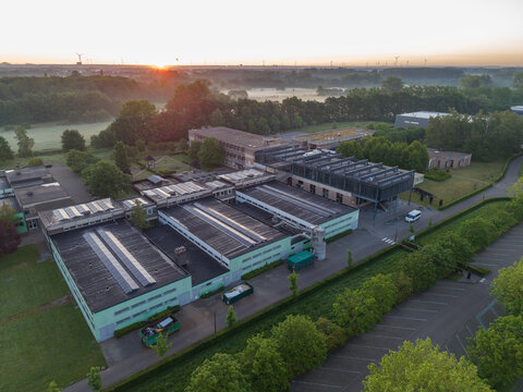 Diepenbeek, Belgium. Aerial drone view of Provinciale School Diepenbeek campus with solar panels and sustainable infrastructure at sunrise