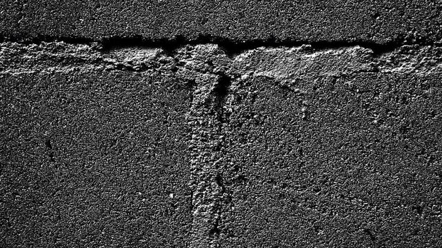 Rough concrete surface with visible seams, cracks, and coarse granular texture throughout.