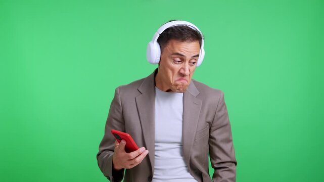 Disgusted businessman listening to music on headphones