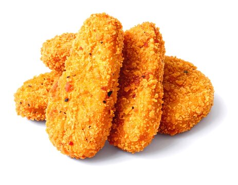 Close-up of breaded and fried chicken-like pieces. Several pieces are stacked on a bright white background, ready for consumption