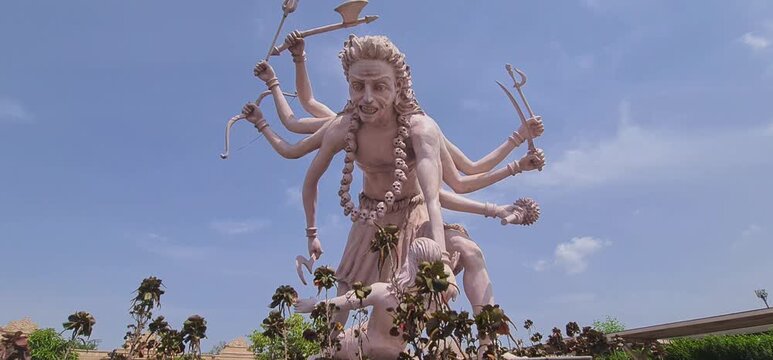 Majestic multi armed sculpture of Lord Bhairava ancient fierce form of Hindu God Shiva under blue sky