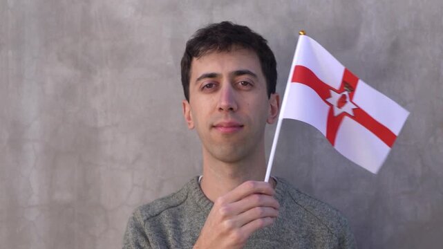 Man waving the Northern Irish flag. Close up in slow motion.