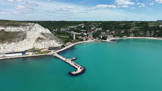 Aerial view of Chirakman Cape featuring white cliffs and a pier extending into the turquoise waters of the Black Sea in Kavarna, Dobrich Province, Bulgaria.