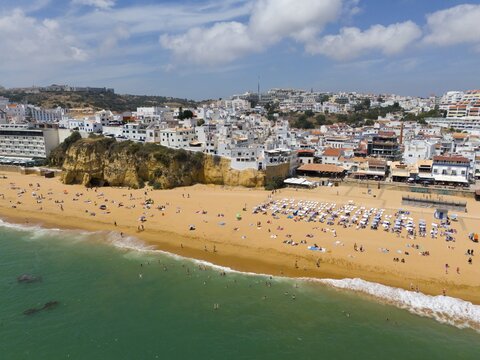 Coastal town with sandy beach, many bathers and buildings along the coast, aerial view, Albufeira, Faro, Algarve, Portugal