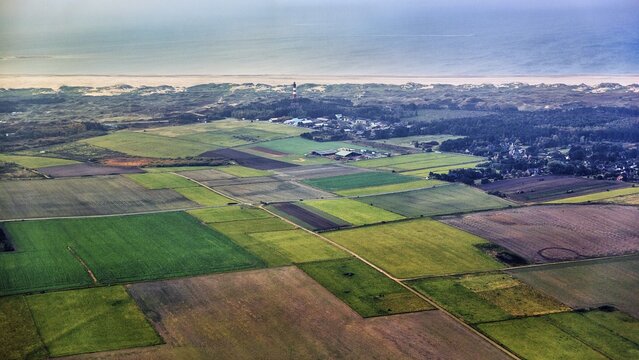 View over fields and meadows, coastline with Amrum lighthouse in the dunes, village of Nebel, haze, aerial view, North Frisian island of Amrum, North Sea, Schleswig-Holstein, Germany
