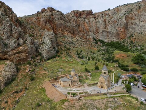 Historic churches embedded in a rocky mountain landscape, surrounded by green vegetation and quietly secluded, aerial view, Noravank Monastery, Surb Astvatsatsin mausoleum church on the right and Surb Karapet Anabaptist church on the left, Noravank, Vayots Dzor province, Vayots Dzor, Armenia, Caucasus