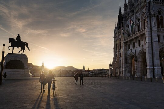 Visitors at the parliament building at sunset, silhouettes against the light, Budapest, Hungary