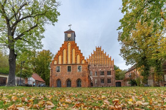 Autumn atmosphere with leaves in the meadow in front of Zinna Monastery with its brick architecture, J&uuml;terbog, Fl&auml;ming, Brandenburg, Germany