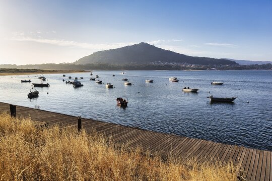 Wooden jetty and boats, mouth of the river Minho in the evening light, Caminha, Viana do Castelo, Portugal