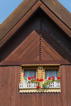 Close-up of a wooden window with red flowers under a blue sky, gable, Old wooden house, Vesec u Sobotky, village conservation area, Libo&scaron;ovice, Libosovice, Okres Jic&iacute;n, Hradec Kr&aacute;lov&eacute;, Czech Republic