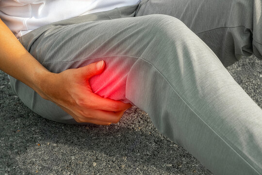 Athlete holding painful hamstring on thigh, showing sports muscle injury and strain, medical photo for treatment, therapy, recovery, and healthcare advertising.