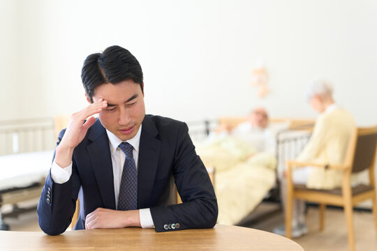 親の介護で悩むアジア人男性