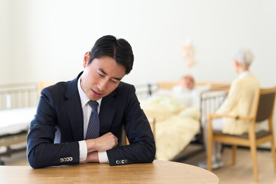 親の介護で悩むアジア人男性