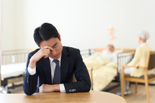 親の介護で悩むアジア人男性